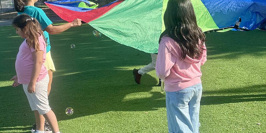 Students playing with bubbles and parachutes