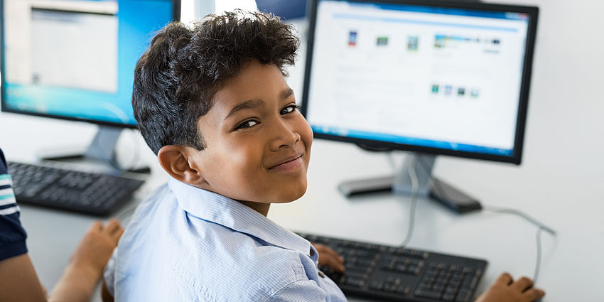 boy smiling at computer