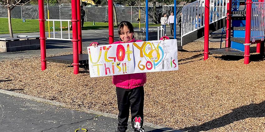 little girl with welcome sign