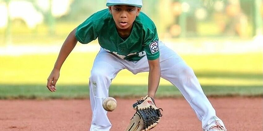 8th grader Liam S. showing his fielding skills on his Little League team in 2024.