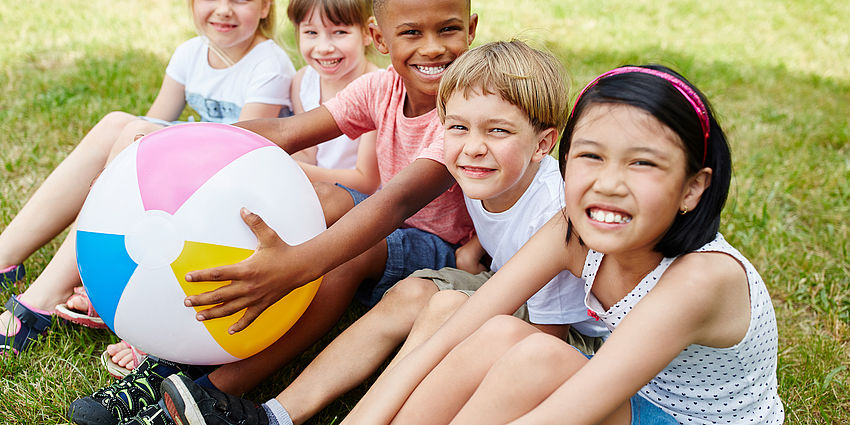 smiling kids sitting on grass