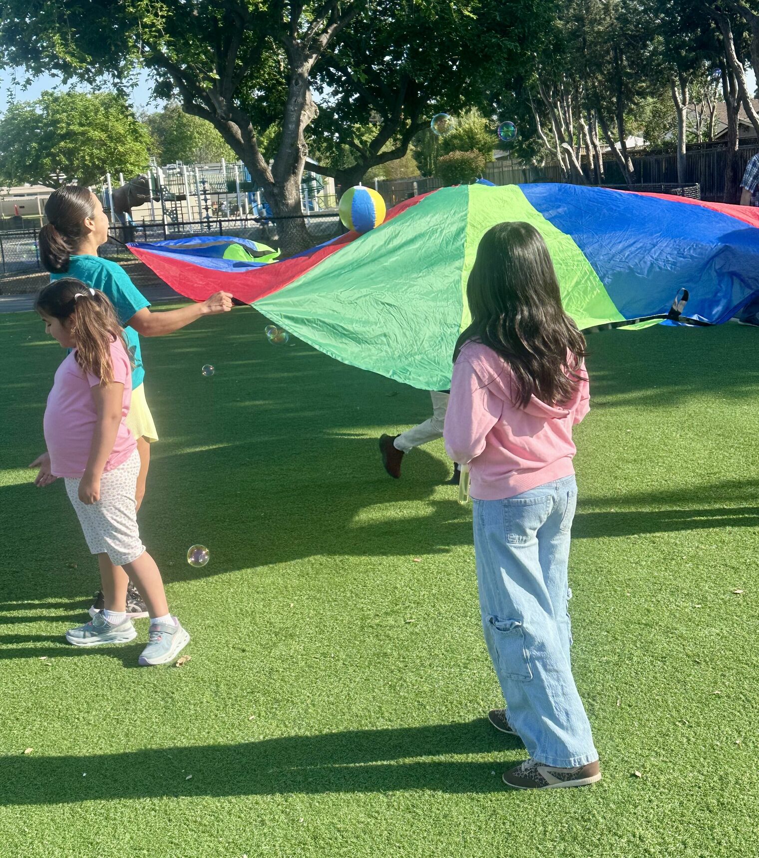 Students playing with bubbles and parachutes