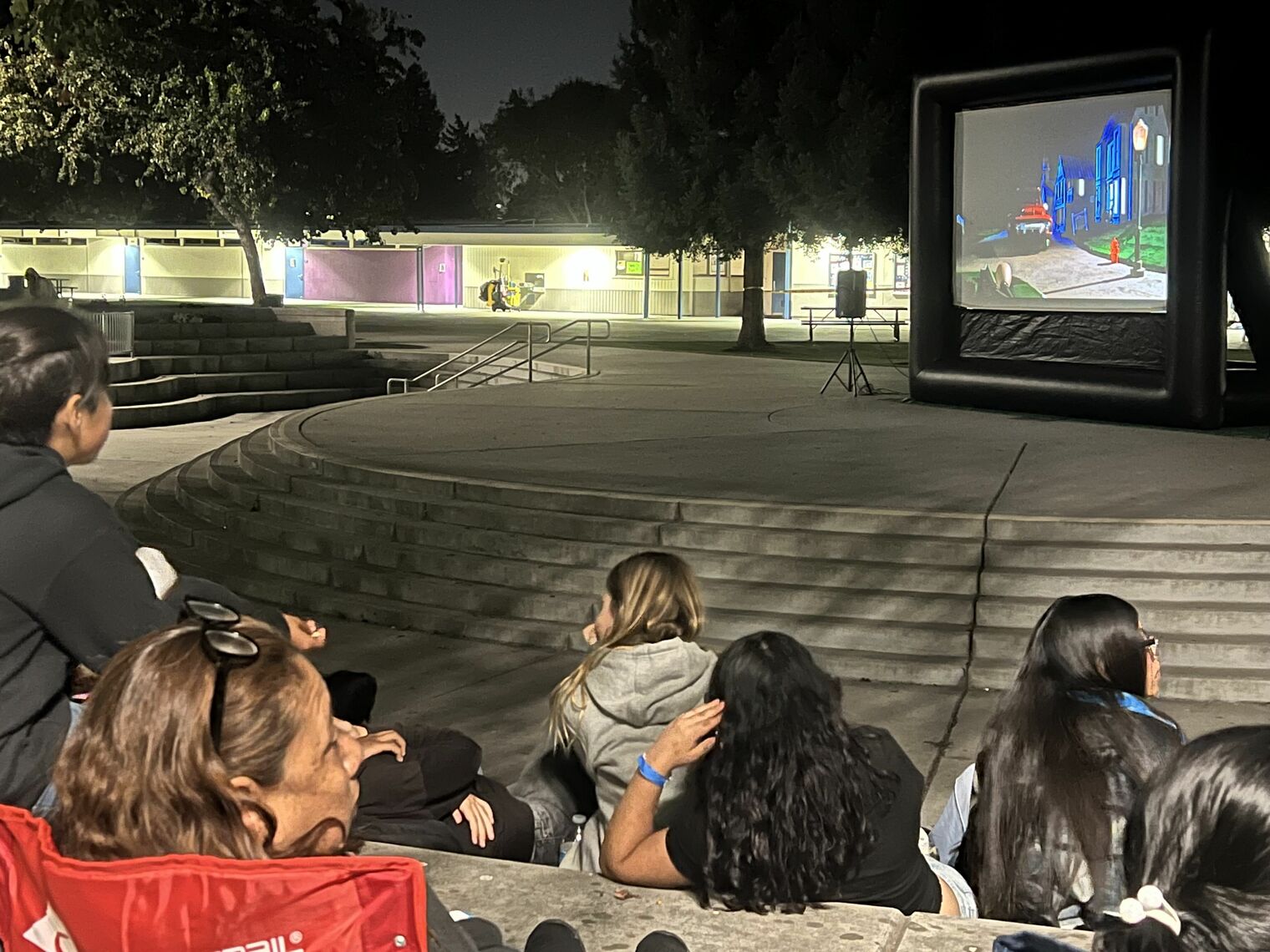 Students and families watching outdoor movie