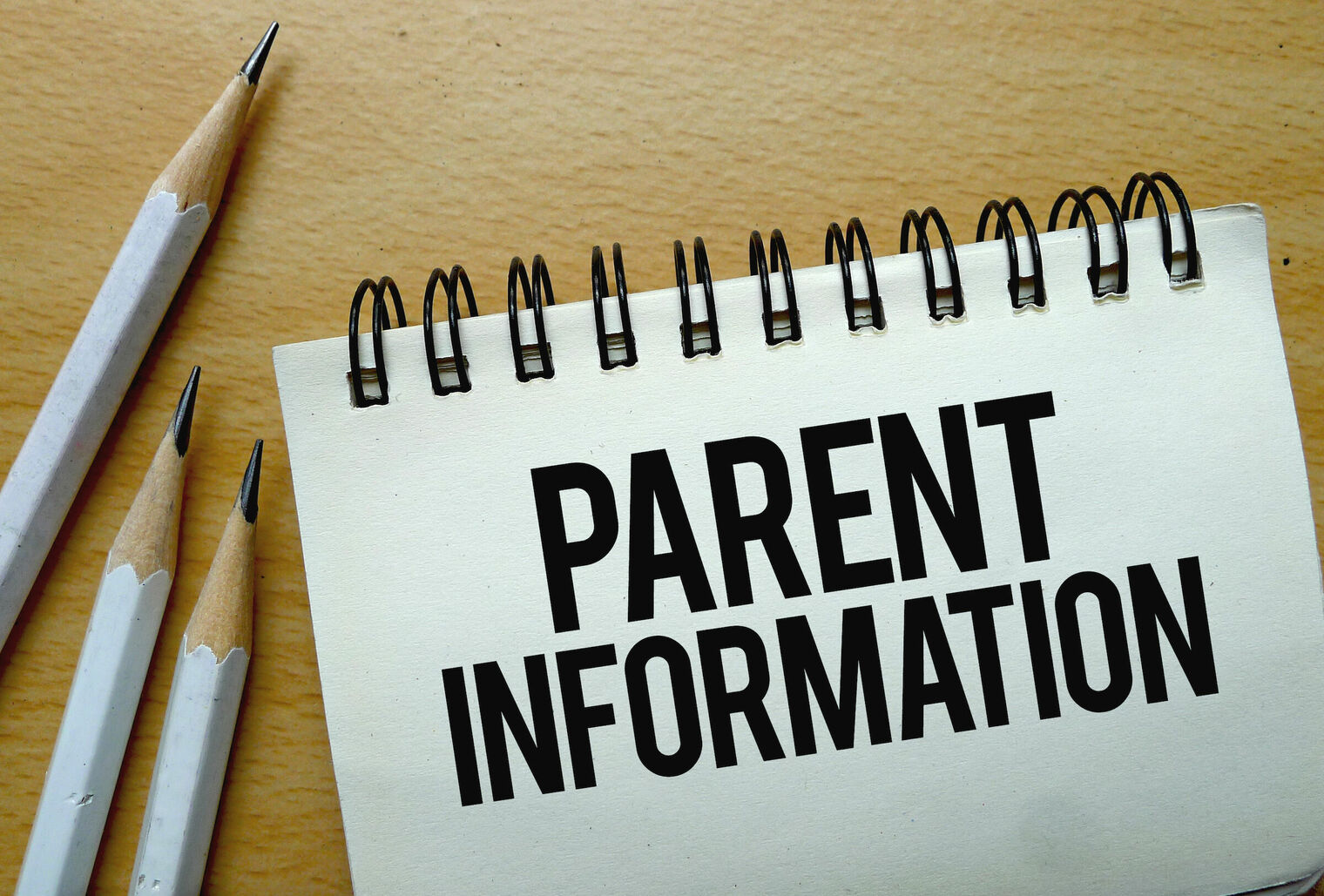 spilar notebook with the words parent information and some sharppened pencils on the side